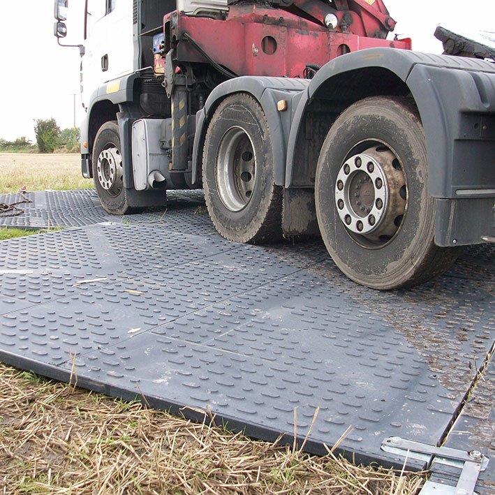 Droga tymczasowa TuffTrak wykorzystana na terenie trawiastym dla pojazdu ciężarowego.